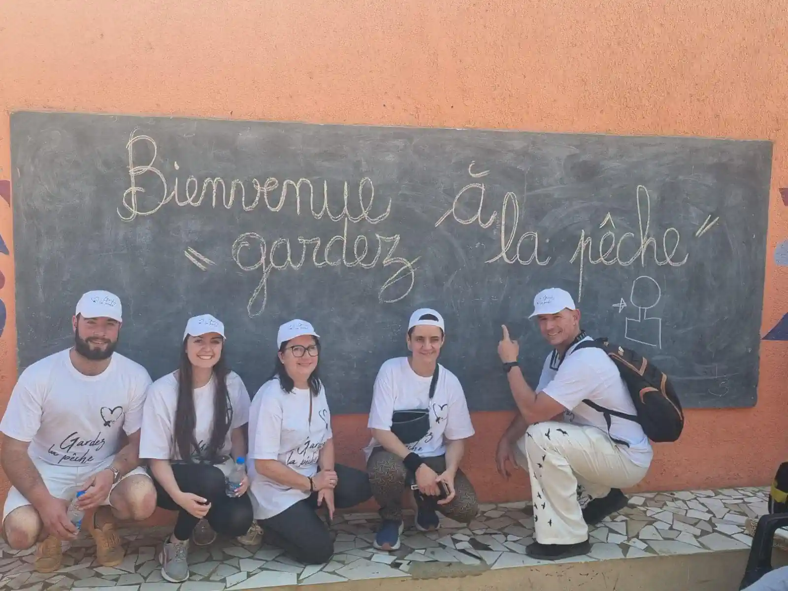 Équipe devant le tableau Bienvenue à Gardez la pêche